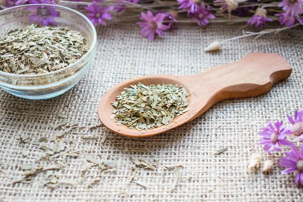 Kuru okaliptüs çul arka plan üzerinde tahta kaşık içinde bırakır. Alternatif bitkisel tıp tıbbi bitki okaliptüs. Sağlık faydaları okaliptüs solunum sağlık, bağışıklık sistemini güçlendirir, cilt sağlığını korumak