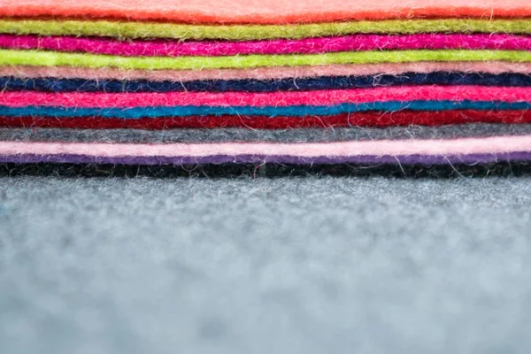 Farklı renk gri kumaş üzerine keçe flep yığını arka plan bulanık. Renkli yığını flep gri kumaş üzerinde hissetti. El yapımı, dikiş, dikiş arka plan, yaratıcılık, el sanatları,