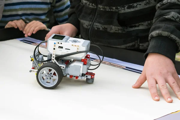 Robot Car, robotics with remote control. Fan robots with children's hands in the background. School Robotics learning for children. Modern training. Model kits. The hottest gadgets.