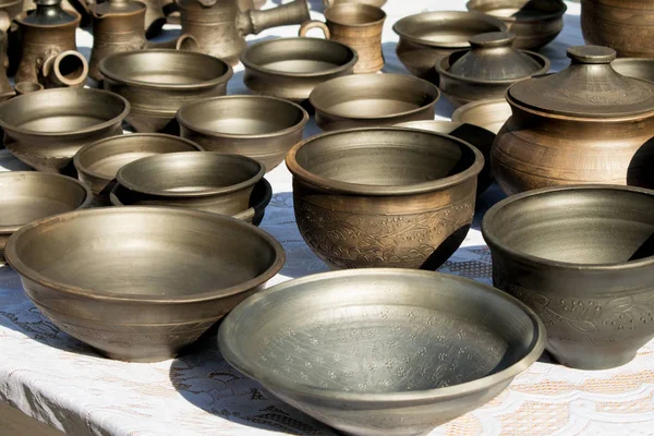 Bir sürü karanlık seramik, geleneksel rustik tarzda. Kil yemekleri. Geleneksel rustik çanak çömlek. Kahverengi ve siyah seramik plakalar, testi, vazolar ve tencere