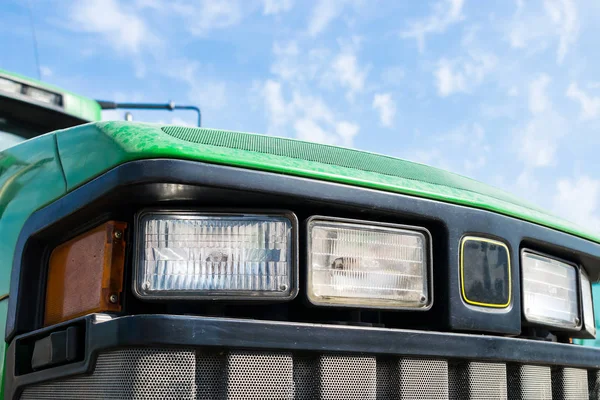 Traktör farlar mavi gökyüzüne karşı satırının kapatın. Traktör beyaz ve turuncu ışıklar bulutlu gökyüzü arka planı. Tarım makineleri. Tasarım ve teknoloji