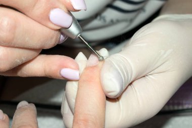İşlem donanım (mekanik) manikür yakın çekim. Tedavi elektrik çivi matkapla çivi. Seçici odak belgili tanımlık gem müşteri çivi. Kavram vücut bakımı.