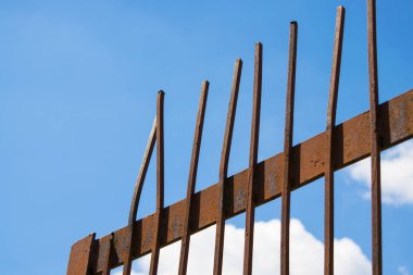 Paslı metal kafes kapı parlak mavi gökyüzü karşı. Köşegen görüntüleme. Terk etme veya özgürlük kavramı