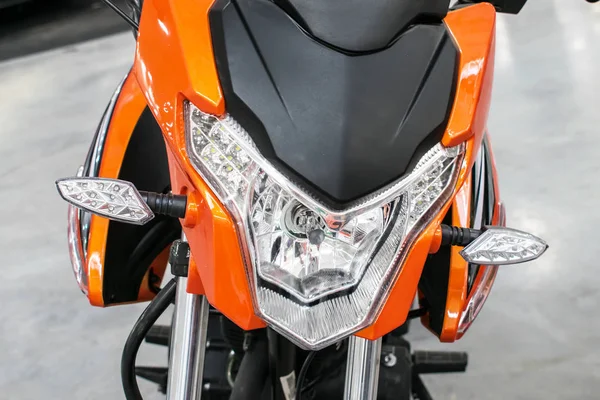 Orange bike, motorcycle, moped with lights. Front view. Front lights of a modern new motorcycle, motorbike. Motorcycle Parts. Transport details