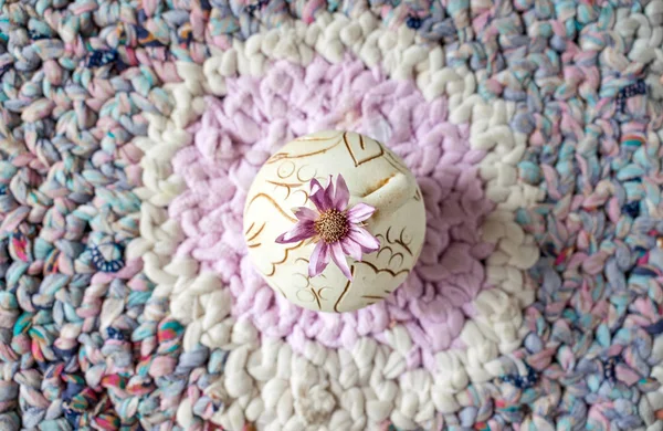 在针织拼接背景纹理背景背景上的圆形粘土花瓶上的淡紫色花 Wabi Sabi Hygge Lagom 简约静物的生活理念 — 图库照片
