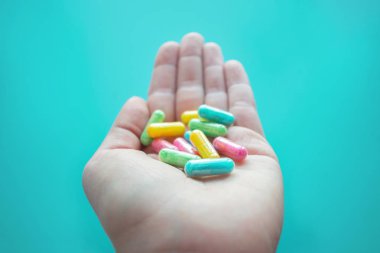 Nootropik, akıllı ilaç, bilişsel arttırıcılar, bileşikler geliştirin Beyin fonksiyonu, geliştirin bellek, bilişsel ve özellikle yönetim işlevleri. Mavi arka plan üzerinde kadın elinde çok renkli kapsül