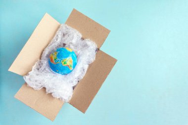 Fiziksel dünya, kopya mavi zemin üzerine karton kutuda plastik wrap Earth'te uzay Recyclable ekoloji sorun çevre kirliliği gezegenin ambalaj plastik dünya gün dünya çevre günü tarafından