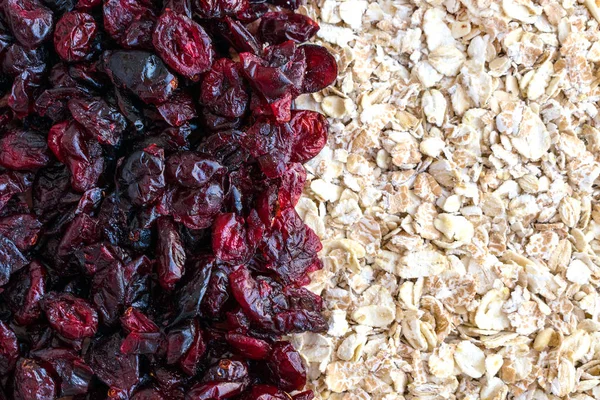 Raw oatmeal with dried cranberries Texture background. Healthy fitness vegetarian breakfast granola meal with cranberries.