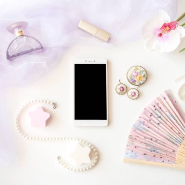 Güzellik ürünleri, mücevher ve akıllı telefon görünümü beyaz arka plan üzerinde top. Şık moda şık hafif mockup. Ruj, Lila eşarp, fan, Smartphone, şişe, bijou, inci boncuk ve orkide çiçek 