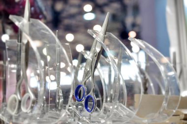 Perakende vitrin vitrininde şık profesyonel berber makasları, saç kesme ve seyreltme makası. Berber dükkanındaki kuaför aletleri. Saç kesimi aksesuarları.