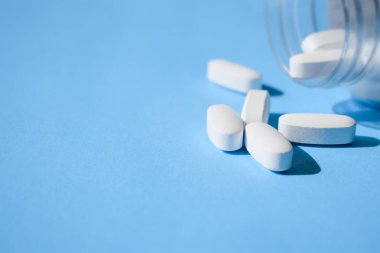 Oksikodon hapları. Opioid ağrı kesici, narkotik. Beyaz hap mavi bir arka plan üzerinde bir şişeyle kapatın