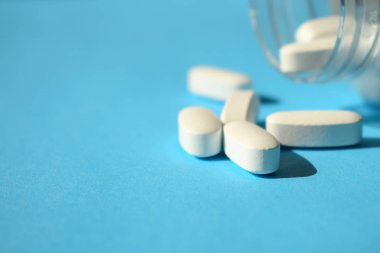 Şeker hapları, yapay tatlandırıcı. Beyaz hap mavi bir arka plan üzerinde bir şişeyle kapatın