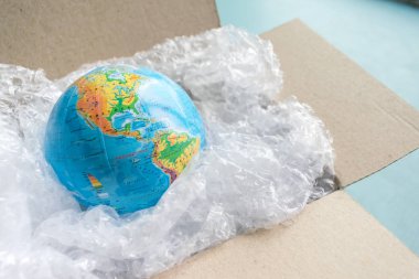Fiziksel dünya, kopya mavi zemin üzerine karton kutuda plastik wrap Earth'te uzay Recyclable ekoloji sorun çevre kirliliği gezegenin ambalaj plastik dünya gün dünya çevre günü tarafından