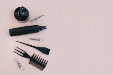 Düz siyah saçlı Minimal kompozisyon salon araçları pastel arka plan üzerinde yatıyordu. Saç boya fırçası ve renk karıştırma için şişe. Saç şekillendirme, boya ve hairdye bej renkli arka plan üzerinde görünümü top