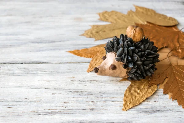 秋の工芸品 子供たちの秋の工芸品や創造性 ハリネズミはモデリング粘土 ひまわりの種 ナッツ 乾燥した黄色葉から作られて 子供の芸術のためのアイデア — ストック写真