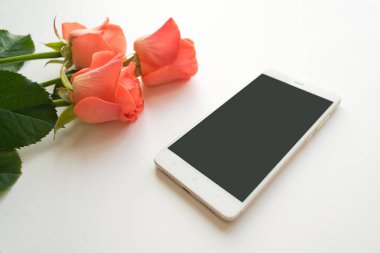 Cep telefonuyla kopya alanı, kırmızı hediye kutusu ve gül beyaz arka planda, alay etmek yukarıya. Kadının çalışma alanı ile telefon ve çiçekler. Boxing günü
