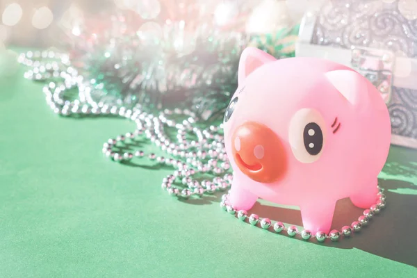 Cute toy Pink Piggy with festive tinsel garland bokeh lights background. Year of pig 2019.  Pig symbol of year, Chinese Horoscope. Richness and wellness. Christmas party.