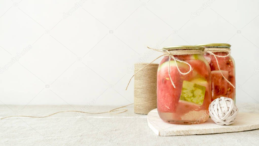 Fermented preserved vegetarian food concept. watermelon slice in glass jars on white rustic kitchen table. Canned food concept. Healthy Gut