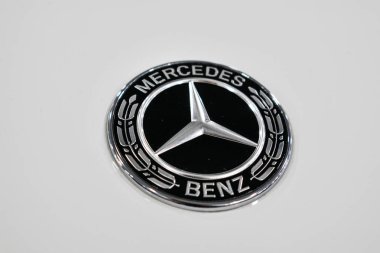  Mercedes Benz logosu kapatmak ve beyaz yeni araba Otomobil Fuarı, otomobil Salon, seçici odak, rozet