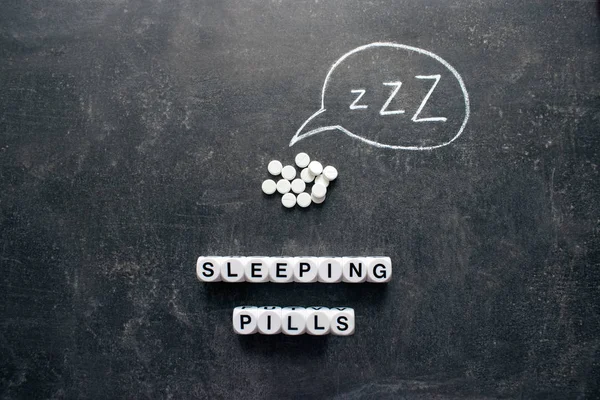 White pills in Z shape and text. Sleeping pills, hypnotic drugs, sedative, melatonin on dark night background