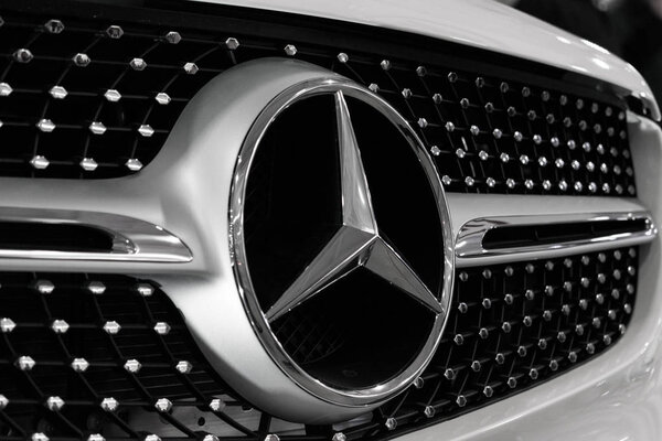 Close up Mercedes Benz logo and badge on radiator grille, new car at motor show, Automobile Salon , selective focus