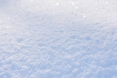 White blue snow texture background with bokeh. Close up of fresh clean snow with blue shadows. Selective focus