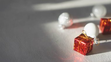 Modern en az Noel şenlikli hediye kış arka plan. Kırmızı hediye kutusu ve beyaz Noel süsleme top gri çimento zemin üzerine kapatın. Noel tebrik kartı arka plan, kopya alanı, seçici odak