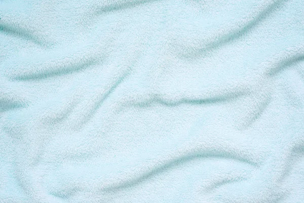 Fluffy Gentle baby blue fabric. Soft pastel textile texture. Folds on the soft fabric. Blue towel terry cloth.