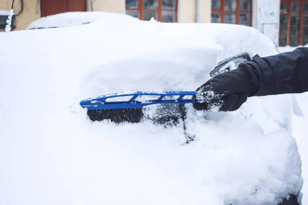 降雪時に雪とブラシとスクレーパーを使って氷から清掃車を男します 緊急の冬 天気関連車両の緊急事態 雪で覆われた自動車 — ストック写真