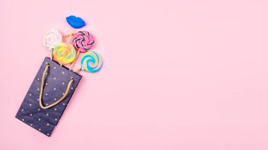 Pastel pembe bac birçok renkli lolipop şekerleri ile kağıt torba