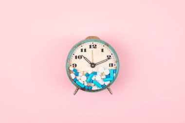 Tabletler, ilaç ve saat yüz hapları ile eski çalar saat o