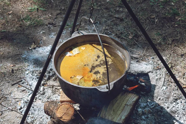 Garnek do wędrówek, Bowler w ognisku. Zupa rybna sprowadza w kocioł — Zdjęcie stockowe