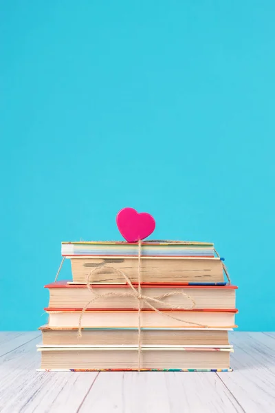 Stack of books and pink heart. Books with jute ribbon bow as gif — Stock Photo, Image