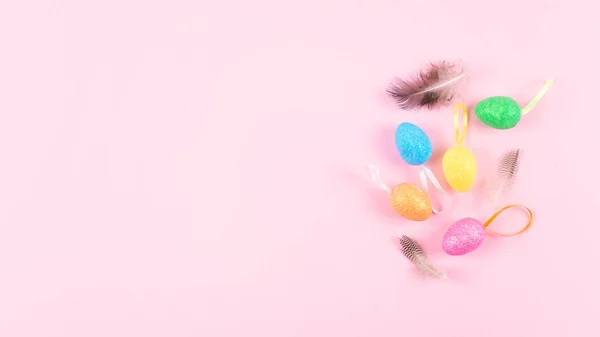Декоративные пасхальные яйца с перьями на розовом фоне. Пасха — стоковое фото