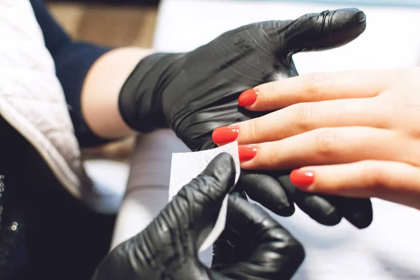 黒手袋のマニキュア専門家は、手の爪を気にします。男 — ストック写真