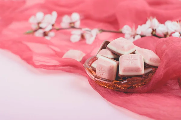 Pink chokolade bar og hvid blomst på lyserød og rød baggrund . - Stock-foto