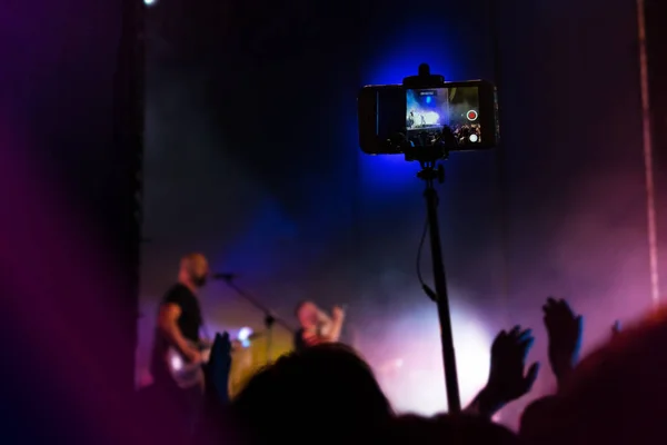 People use smart phones record video at music concert. Crowd at