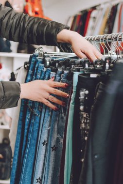 Hızlı moda konsepti. Kadın kotları mağazadan seçiyor. Bir sürü.