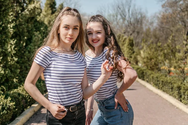 Dos jóvenes amigas sonrientes divirtiéndose en el parque. Dos te —  Fotos de Stock