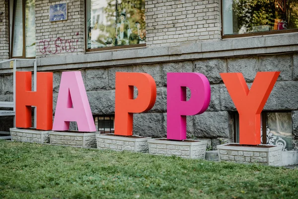 Grandes letras multi-coloridas HAPPY na rua da cidade, street art insta — Fotografia de Stock