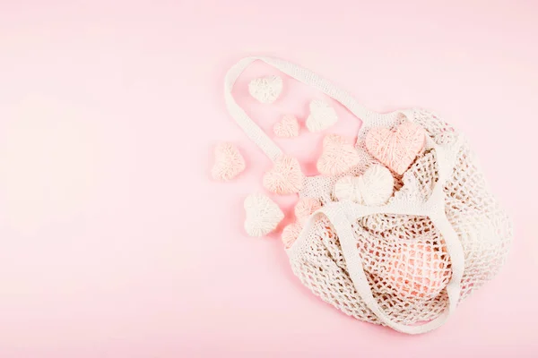 Mehrweg-Netztasche mit weißen und rosafarbenen Strickherzen — Stockfoto