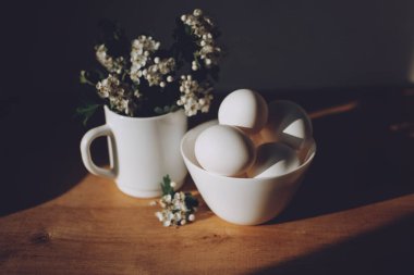 Ulusal yumurta günü arka planında beyaz yumurtalar ve yeşil vazoda çiçekler. 3 Haziran 'da Ulusal Yumurta Günü