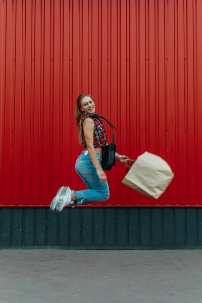 Chica Feliz Con Bolsa Papel Compras Fondo Tienda Pared Roja —  Fotos de Stock