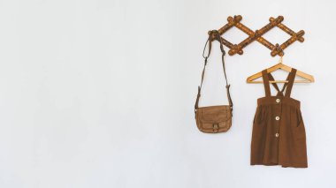 Şirin çocuk odası dekorasyon fikirleri, Bebek Odası dekorasyonu. Bebek bebek askıda asılı organik pamuk giysiler ve beyaz duvarda eski püskü aksesuarlar