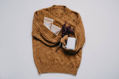 Sonbahar havası, kakao, sıcak çikolata zamanı. Sıcak çikolata, kakao tozu, marşmelov ve örülmüş süveter arka planında beyaz bardak..