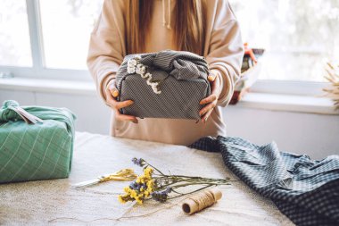 Furoshiki Japon Hediye Paketi. Şükran Günü ziyanı, çevre dostu hediye paketleme süreci, özel ders. Geleneksel Japon Furoshiki tarzında el yapımı bir hediye.