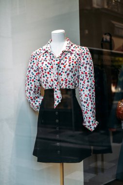 Puantiyeli bluz giymiş bir manken. Kravatlı ve butik bir pencerede yüksek bel etekli. Modern retro diriliş, klasik moda, kadınsı tarz, şehir perakendecisi. Yüksek kalite fotoğraf