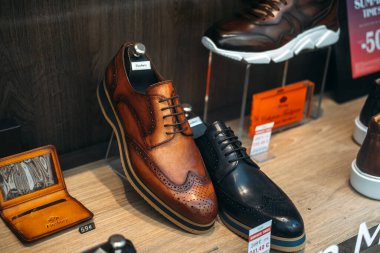 Zarif erkekler kahverengi ve siyah deri ayakkabılar giyer ve bir butik mağazasının vitrininde 19 Ağustos 2025 tarihli Lyon France etiketli ve aksesuarlı delikli detaylar sergilenir. Yüksek kalite fotoğraf