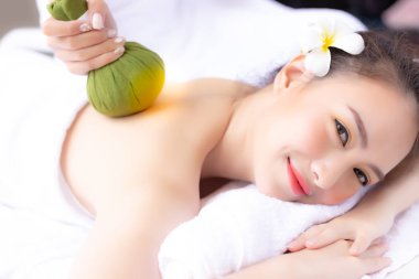 Masaj gençleştirmek ve geri bitkisel topu kullanarak sevimli güzel kadın masaj. Çekici kız rahat ve mutlu hissediyorum. Güzel Bayan memnun alır. Onun aromaterapi masaj gülümseme ile.