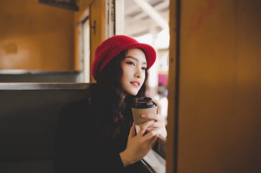 Portre sevimli güzel gezgin kadın. Çekici güzel kadın Turizm konum veya turistik cazibe vintage tren ile seyahat ediyor. Muhteşem bir kadın manzaraya bak ve bir fincan kahve tutar